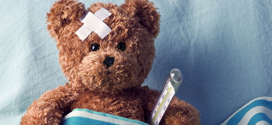 A teddy bear with a plaster and thermoter